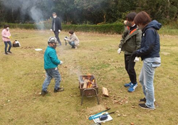 日帰りキャンプで火おこしをする写真