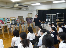 教員が生徒の油彩画を講評している画像