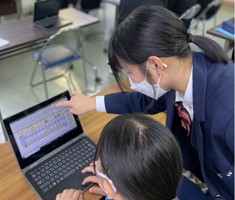 高校生が中学生にパソコンの使い方を教えている画像