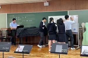 先生が弾いた曲をホワイトボードに書いている写真