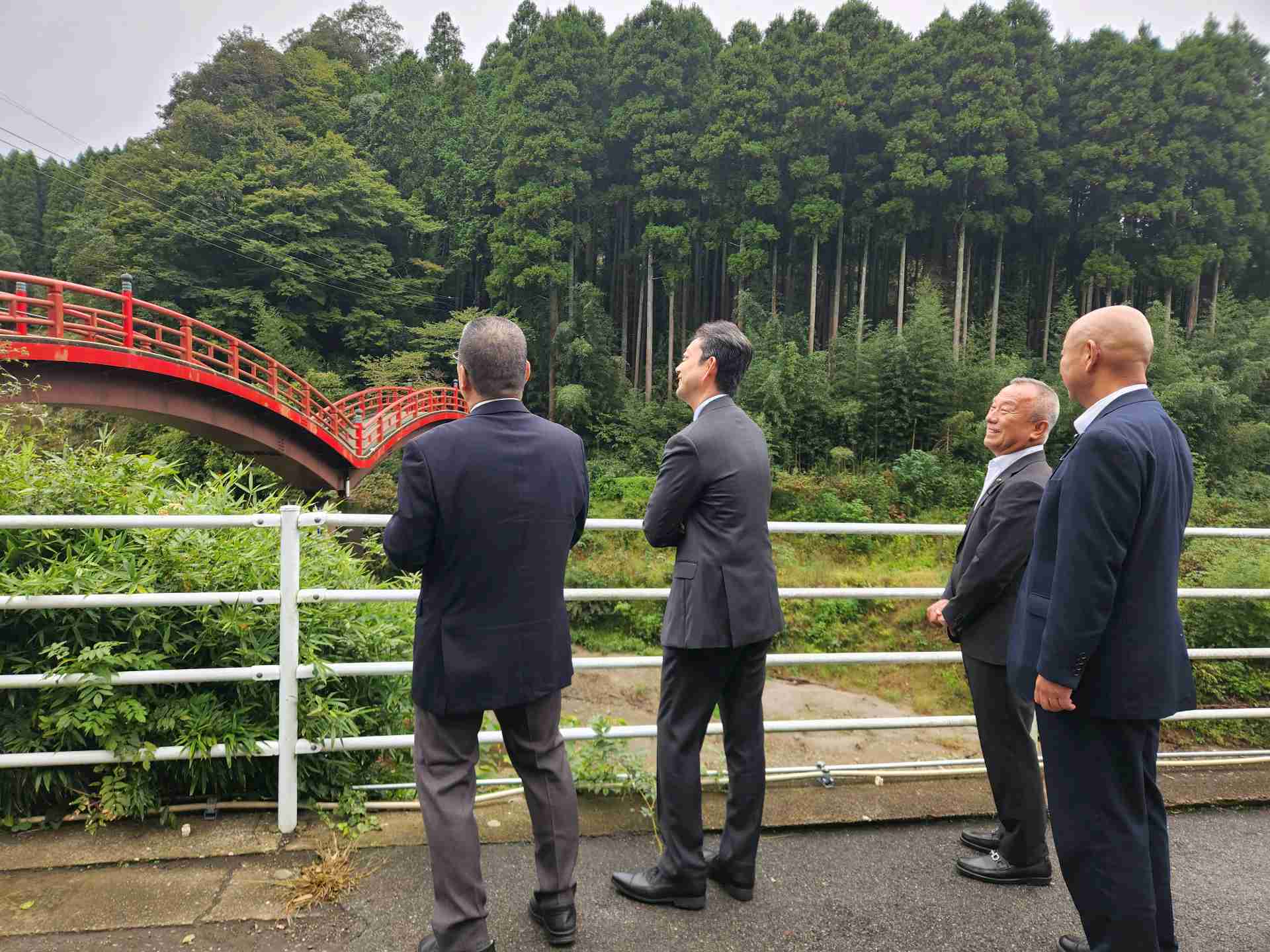 養老渓谷温泉街周辺における現地視察の際、橋を見ながら町長の説明を聞く知事の画像