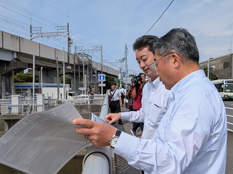 見明川河口部における現地視察の際、市長の説明を聞きながら視察をする知事の画像