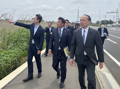 銚子連絡道路匝瑳インターチェンジ周辺における現地視察の際、視察先を指さしながら匝瑳市長の説明を受ける知事の画像