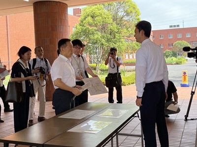 南流山中学校における現地視察の際、市長の説明を聞く知事の画像