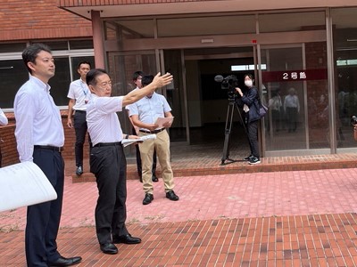 南流山中学校における現地視察の際、2号館付近で市長の説明を聞く知事の画像