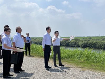 主要地方道越谷野田線野田橋周辺における現地視察の際、市長の説明を聞く知事の画像