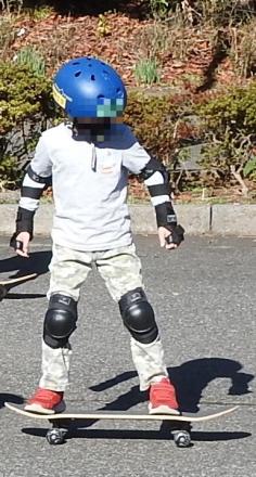 プロテクターを着用してスケートボードに乗るスケーター